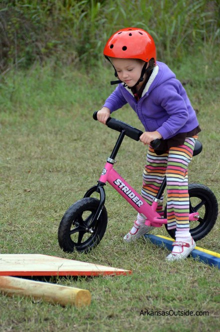 2012-10-06_1520 Negotiating the beginner obstacle course on a pretty pink Strider balance bike.